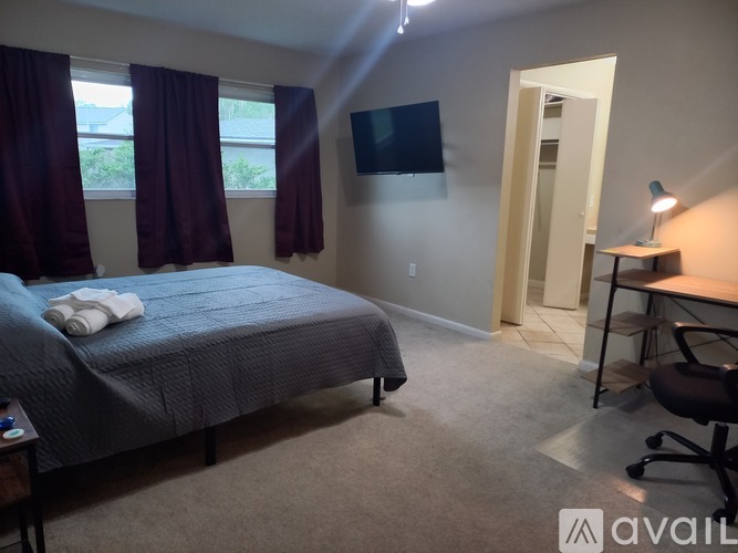 A bedroom with a bed, desk, and chair.
