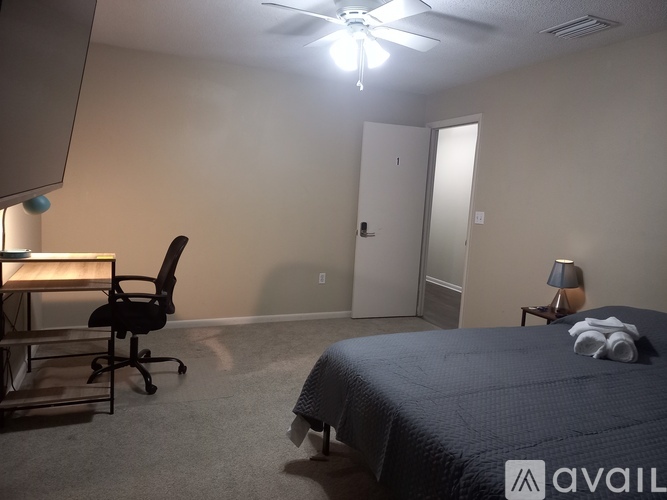 A room with a bed, desk, and chair.