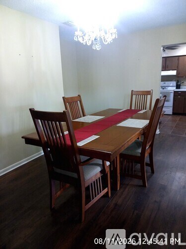 A dining room with a wooden table and chairs.