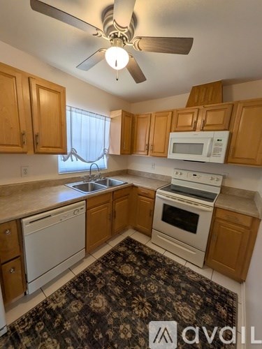 A kitchen with wooden cabinets and a white fridge.