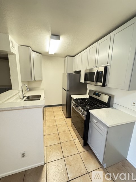 A kitchen with white cabinets and appliances.
