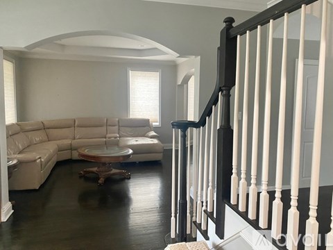 A living room with a white couch and a wooden coffee table.