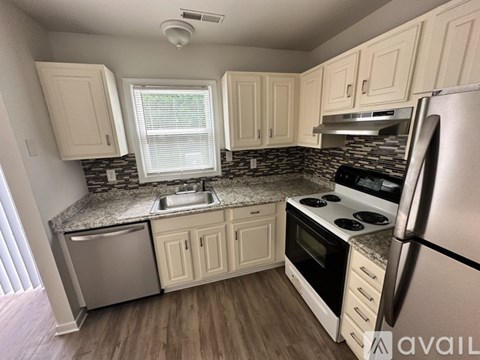 A kitchen with white cabinets and a granite countertop.