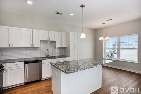 A kitchen with white cabinets and a granite countertop.