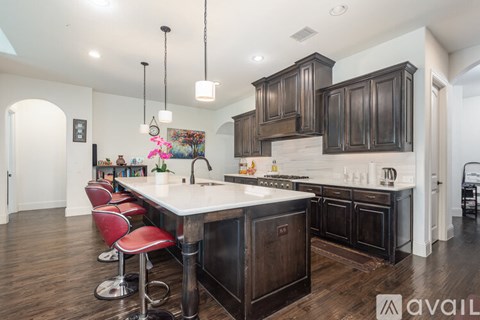 A kitchen with dark wood cabinets and a white island.
