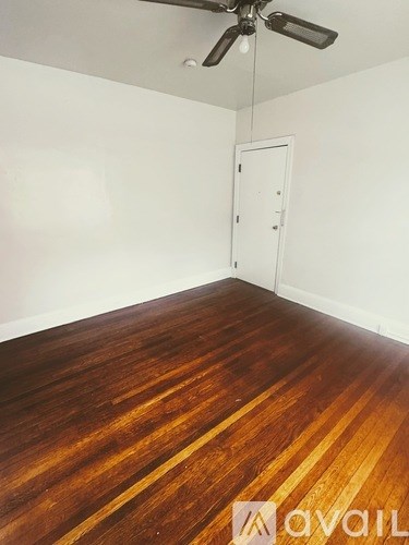A room with wooden flooring and a ceiling fan.
