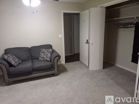 A living room with a grey couch and a white wardrobe.