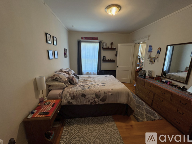 A bedroom with a bed, dresser, and mirror.
