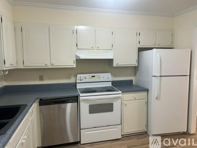 A kitchen with white appliances and cabinets.