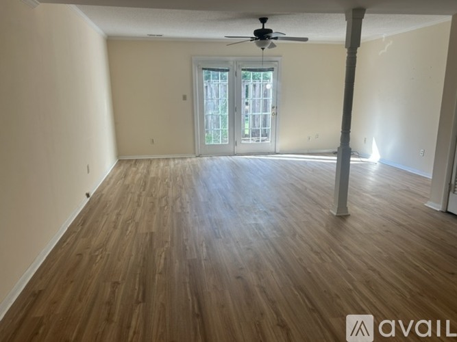 A room with wooden flooring and a ceiling fan.