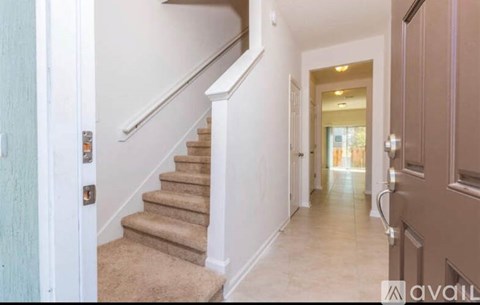 A hallway with a staircase leading to the second floor.
