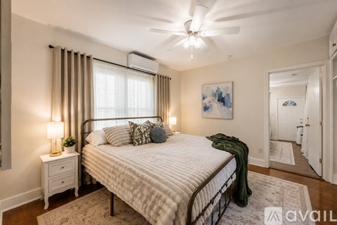 A bedroom with a large bed and a ceiling fan.