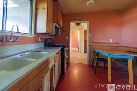A kitchen with a sink, stove, and a table.