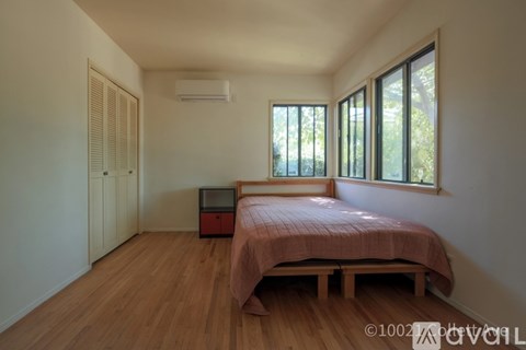 A bedroom with a bed, dresser, and window.