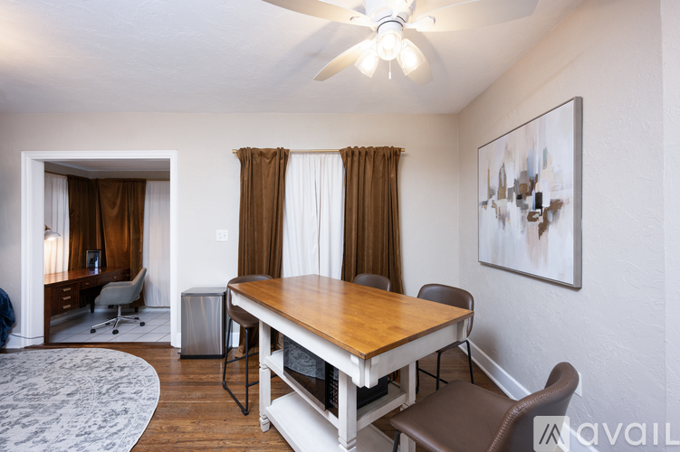 A dining room with a wooden table and chairs.