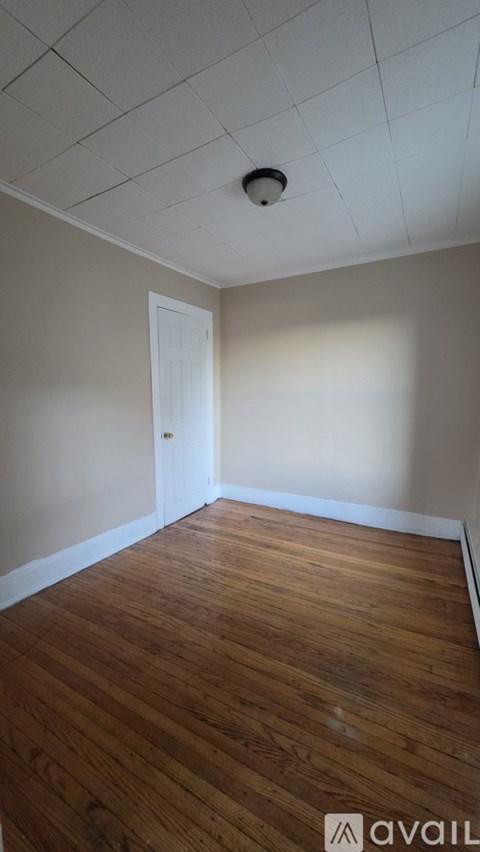 A room with wooden flooring and a white door.