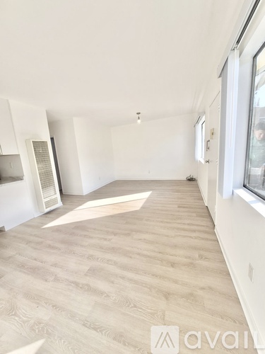 A room with a light wooden floor and white walls.