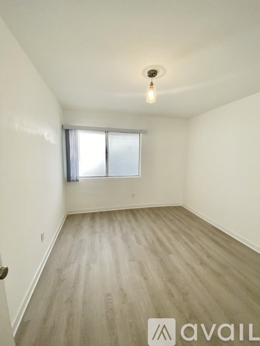 A room with wooden flooring and a window.