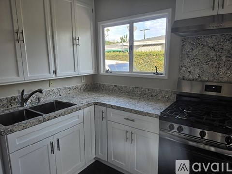 A kitchen with white cabinets and a black stove top oven.