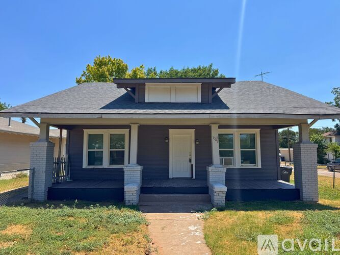 A house with a front porch and a white door is for sale.