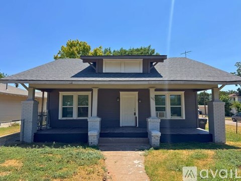 A house with a front porch and a white door is for sale.