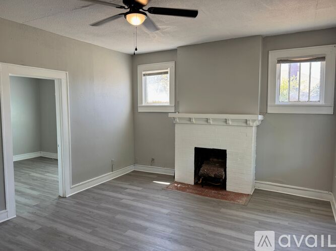 A room with a fireplace and a ceiling fan.