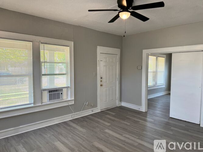 A room with a ceiling fan and a window with blinds.