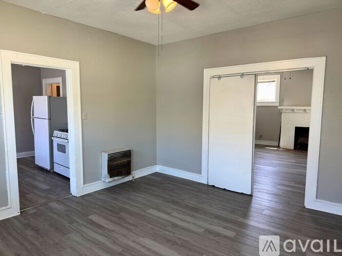 A room with a white door and a white fridge.
