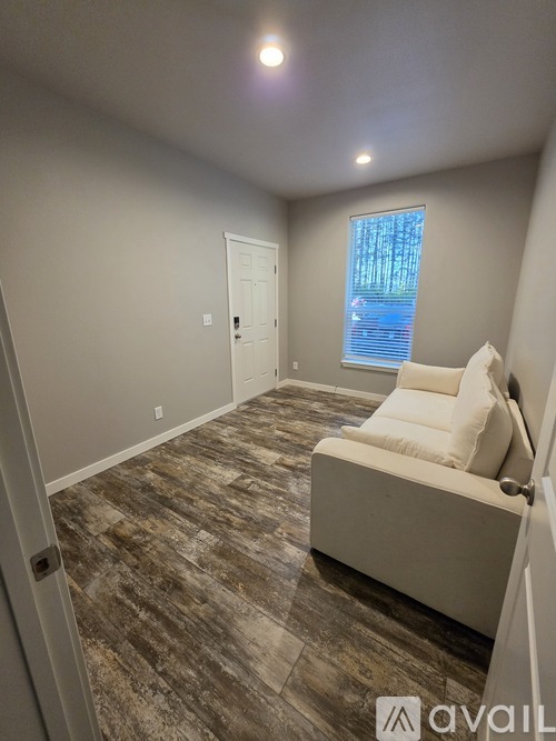 A living room with a couch and a window.