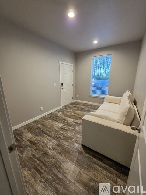 A living room with a couch and a window.