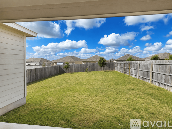 A backyard with a wooden fence and a grassy area.