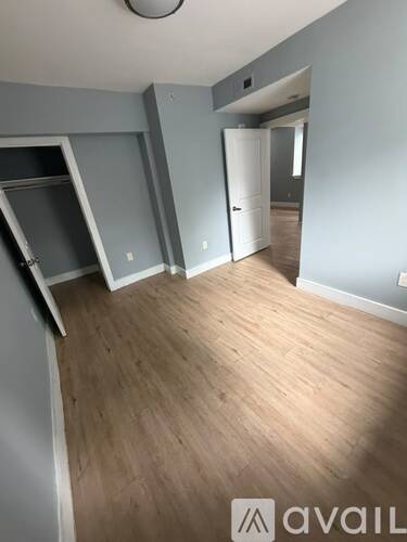 A room with wooden flooring and a white door.