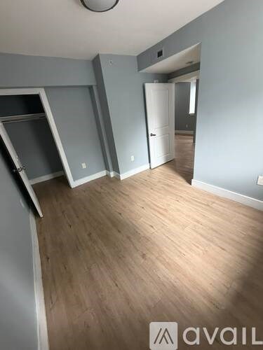 A room with wooden flooring and a white door.