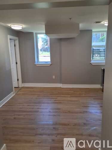 A kitchen with wooden floors and grey cabinets.