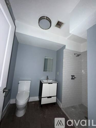 A bathroom with a toilet, sink, and a shower.