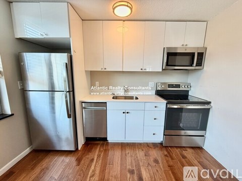 A kitchen with wooden floors and stainless steel appliances.