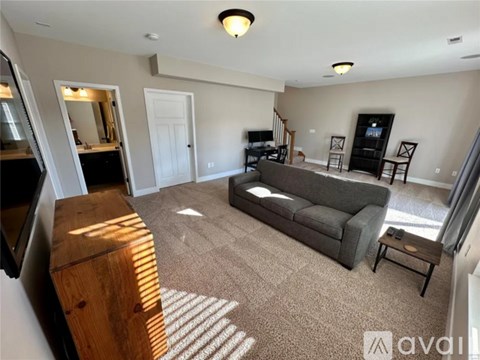 A living room with a grey couch and a wooden cabinet.