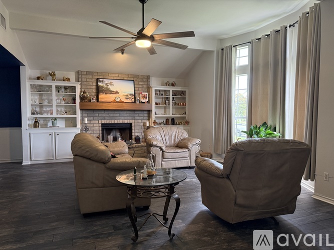 A living room with a fireplace and a painting on the wall.
