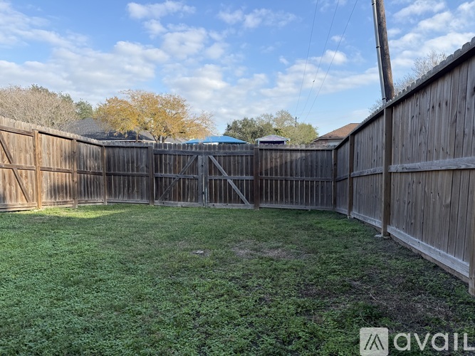A backyard with a wooden fence and a grassy area.