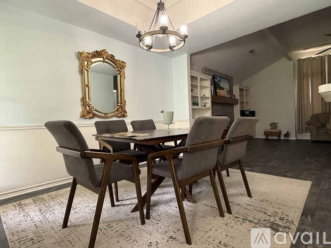 A dining room with a table and chairs.