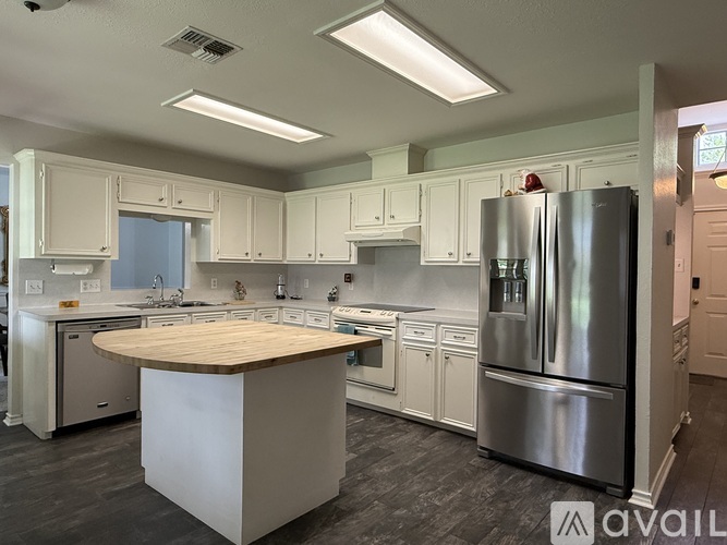 A modern kitchen with stainless steel appliances and white cabinets.