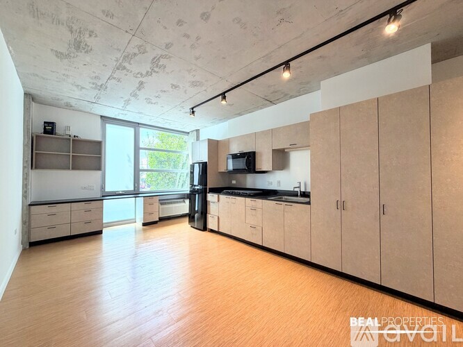 A spacious kitchen with wooden floors and white walls.