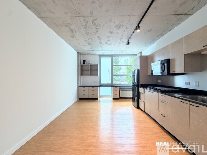 A kitchen with wooden floors and a large window.
