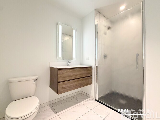 A white toilet sits next to a sink in a modern bathroom.
