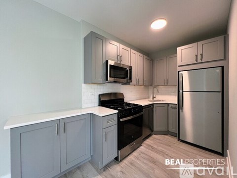 A kitchen with a stove top oven, microwave, and refrigerator.