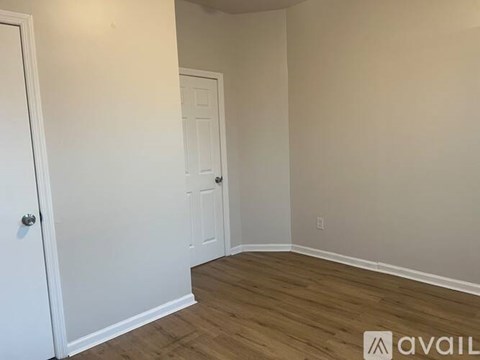 A room with a white door and a white wall.
