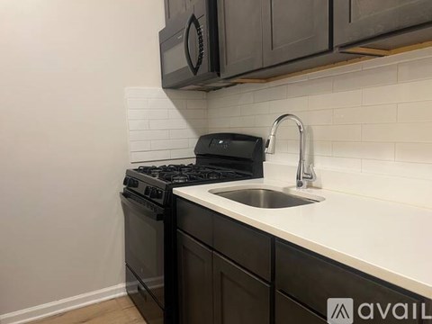 A kitchen with a black stove and a white sink.