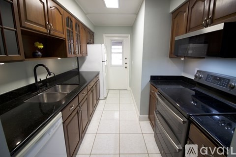 A kitchen with black countertops and brown cabinets.