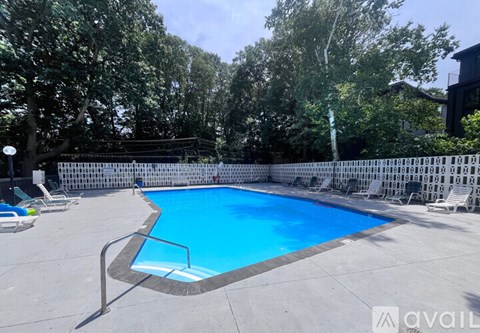 A small pool surrounded by a white fence and trees.