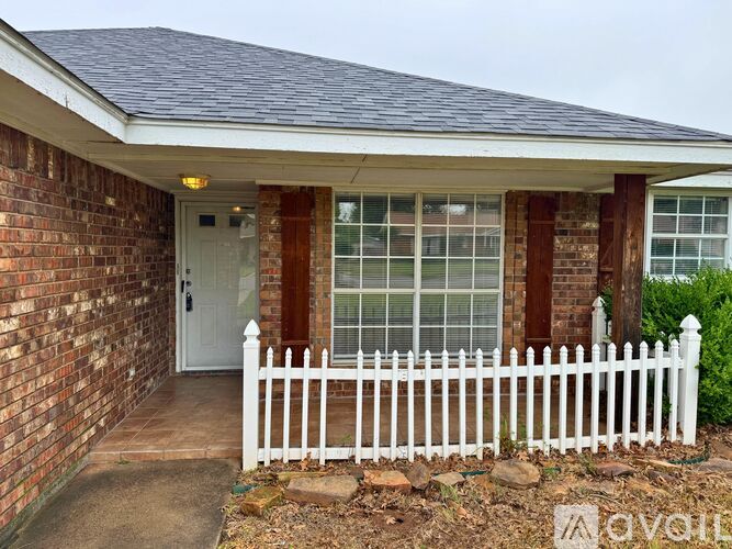 A house with a white picket fence in front.
